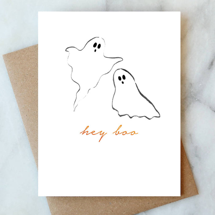 Hey Boo Halloween greeting card with ghost illustrations and kraft envelope on marble surface