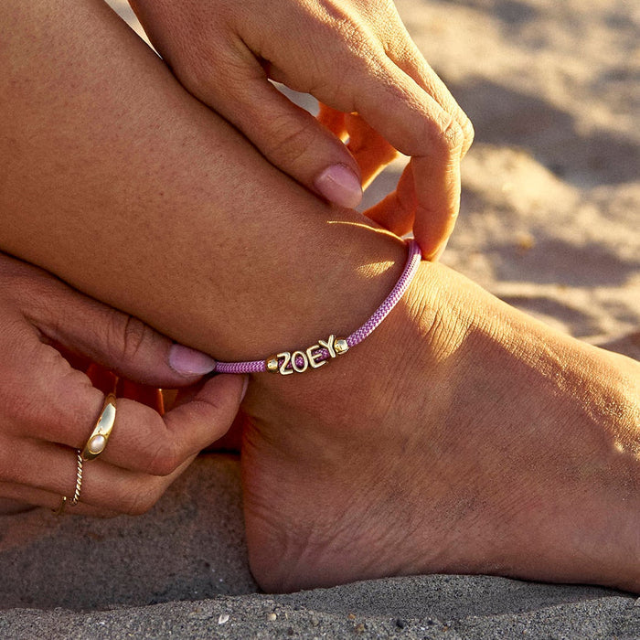 Person applying sunscreen to their leg on a sandy beach