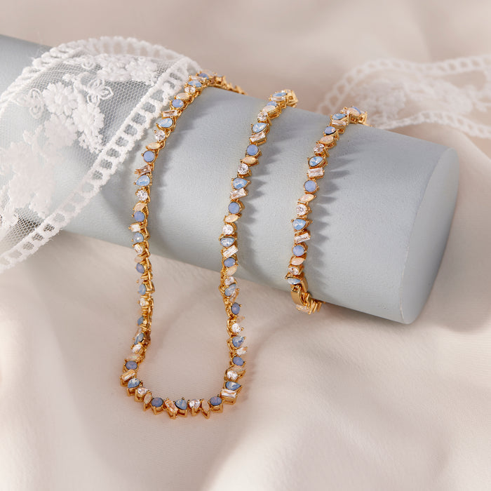 Gold bracelet with blue stones on a white lace background