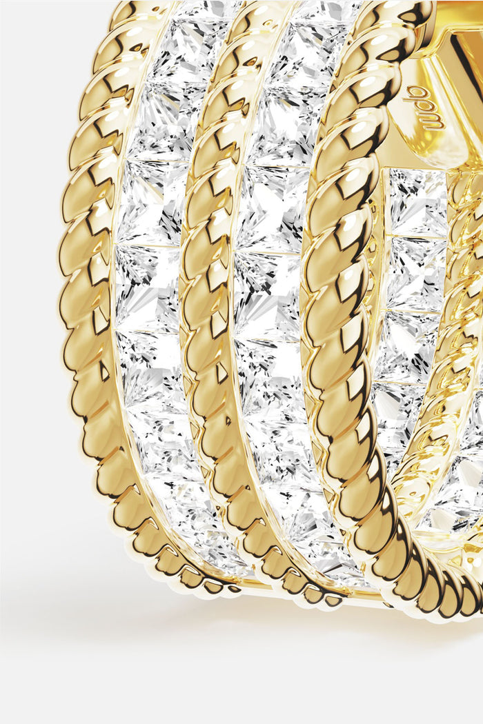APM Ring in golden color, twisted rope lines and radiant stones, quietly luminous.