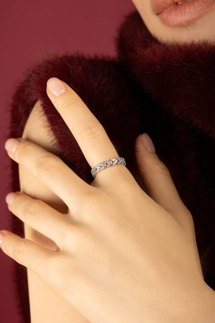 Woman wearing APM Monaco ring, a shimmering whisper against velvet warmth.