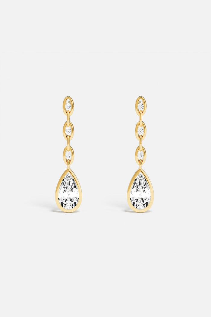 APM drop earrings, a golden cascade ending in luminous elegance.