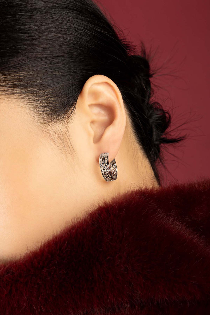 Woman wearing APM Monaco hoop earrings, a sparkling whisper of quiet elegance.