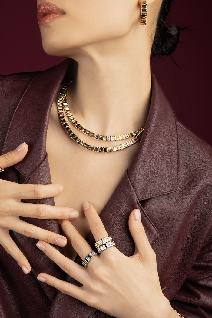 Woman wearing APM Monaco jewelry set, golden allure meets modern sophistication.