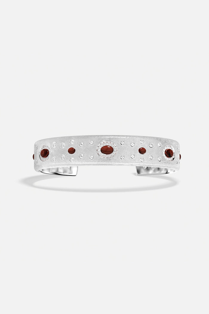 APM Cuff Bracelet, brushed rhodium finish scattered with deep red accents, quietly radiant.