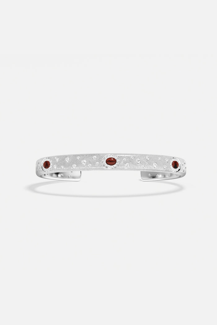 APM Monaco cuff bracelet in rhodium finish, sprinkled with sparkle and deep red accents.
