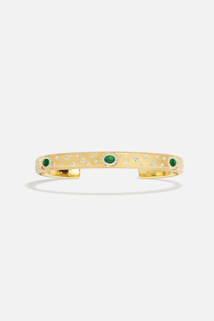APM Monaco cuff bracelet in golden hues, scattered with emerald green stardust.
