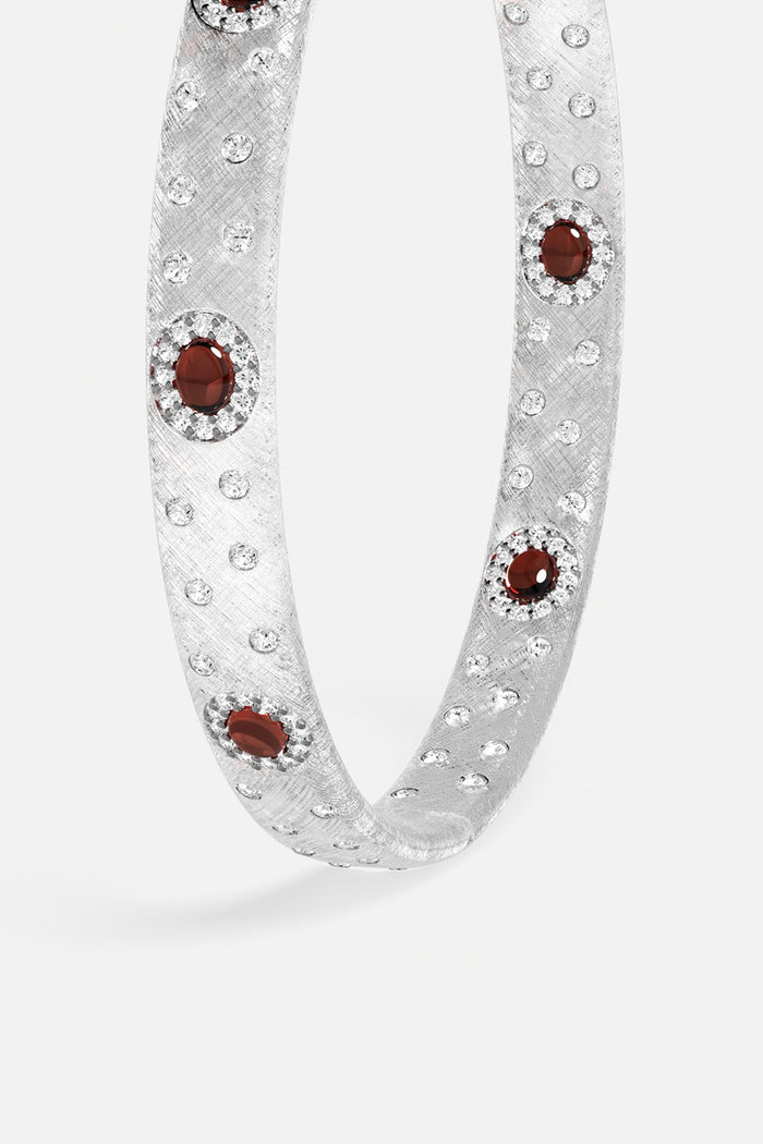 APM Bracelet in rhodium finish, scattered with crimson stones for quiet allure.