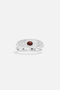 APM Ring in rhodium finish, a deep red gem glowing with quiet elegance.