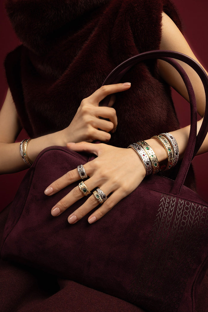 Woman wearing APM Monaco bangles and rings, a rich stack of quiet opulence.
