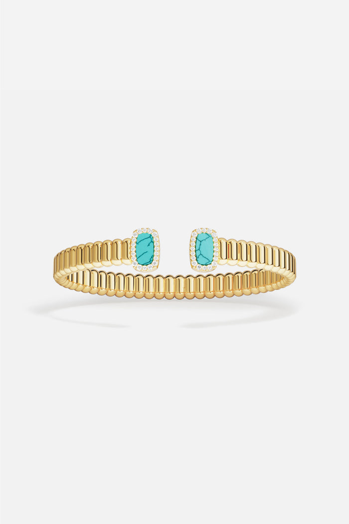 APM Monaco cuff bracelet in golden ribbed elegance, kissed by turquoise serenity.