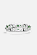 APM Bangle in rhodium finish, radiant with deep green hues and luminous sparkle.