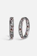 APM Hoop Earrings in rhodium finish, radiant with deep garnet colors and quiet audacity.