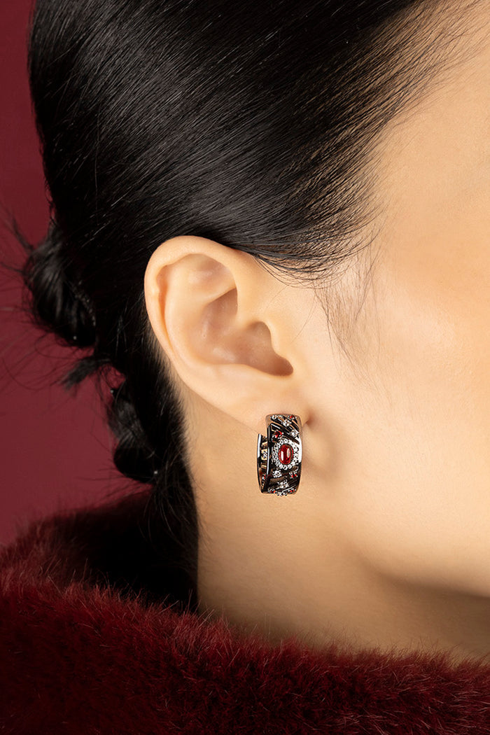 Woman wearing APM Hoop Earrings, a bold whisper of red and rhodium finish.