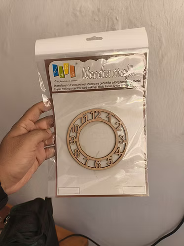 Wooden Crafts 4 inch MDF laser-cut clock numbers frame in packaging, held in hand — wood veneer craft piece for card making and resin art