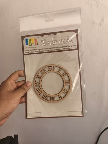 4 inch MDF laser-cut Roman numeral clock frame in packaging, held in hand — wood veneer craft piece for card making and resin art