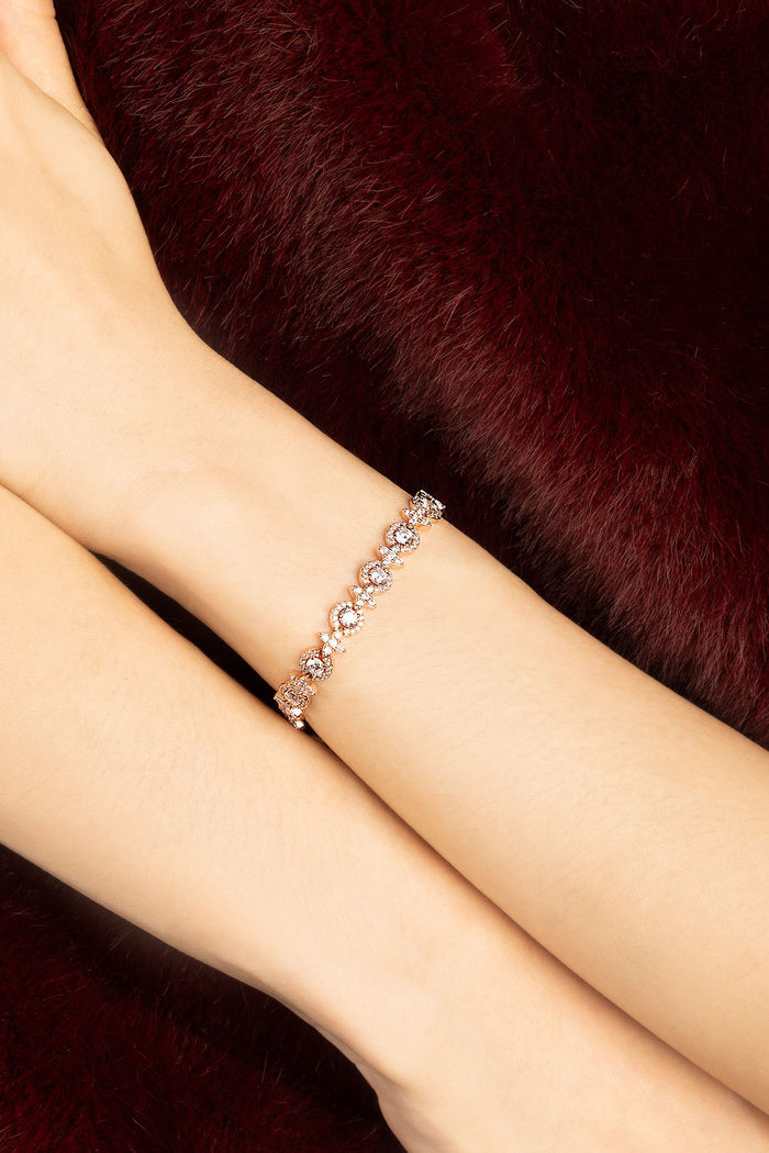 Woman wearing APM bracelet, a delicate sparkle against velvet warmth.