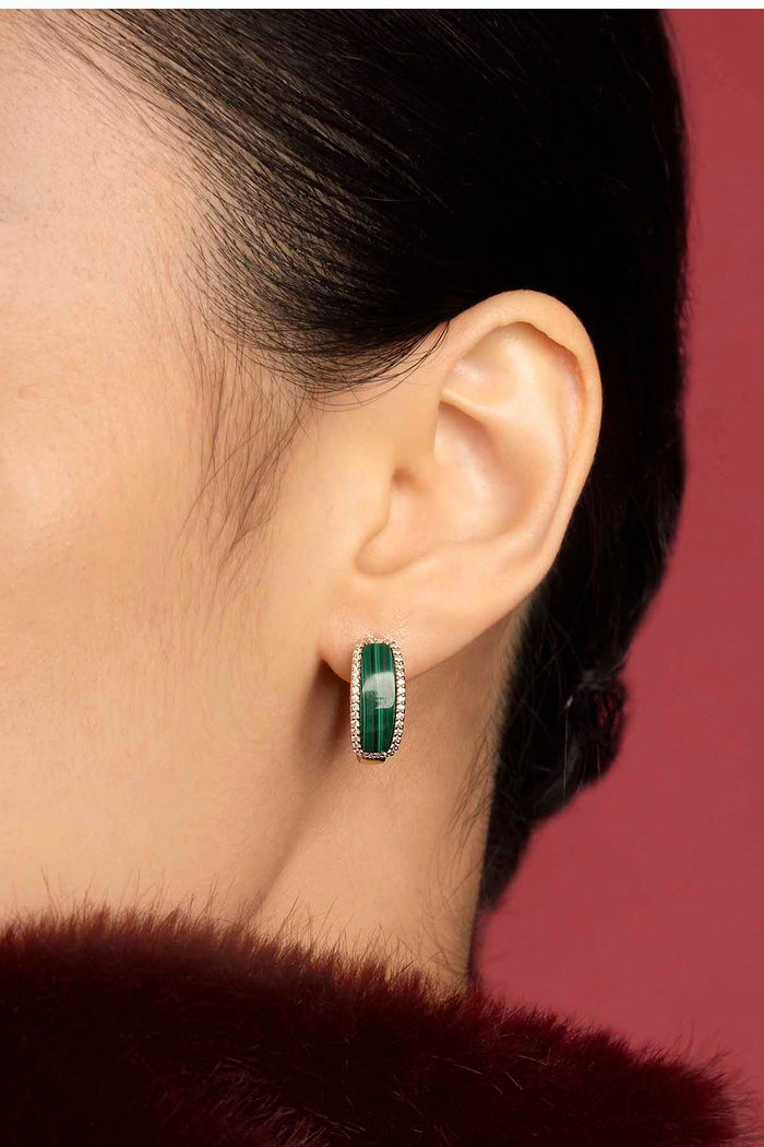 Woman wearing APM Earrings, a bold green stone framed in quiet elegance.