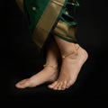 Gold anklet with a clasp on a gray background, featuring the brand 'Saheli'.