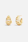 APM Monaco earrings in golden hues, sculpted lines meeting a shimmering embrace of light.