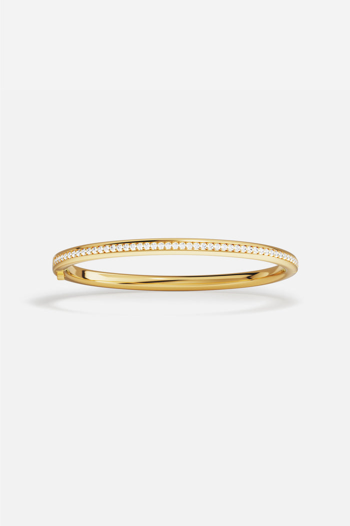 APM Bangle in golden hues, a sleek line of quiet radiance.