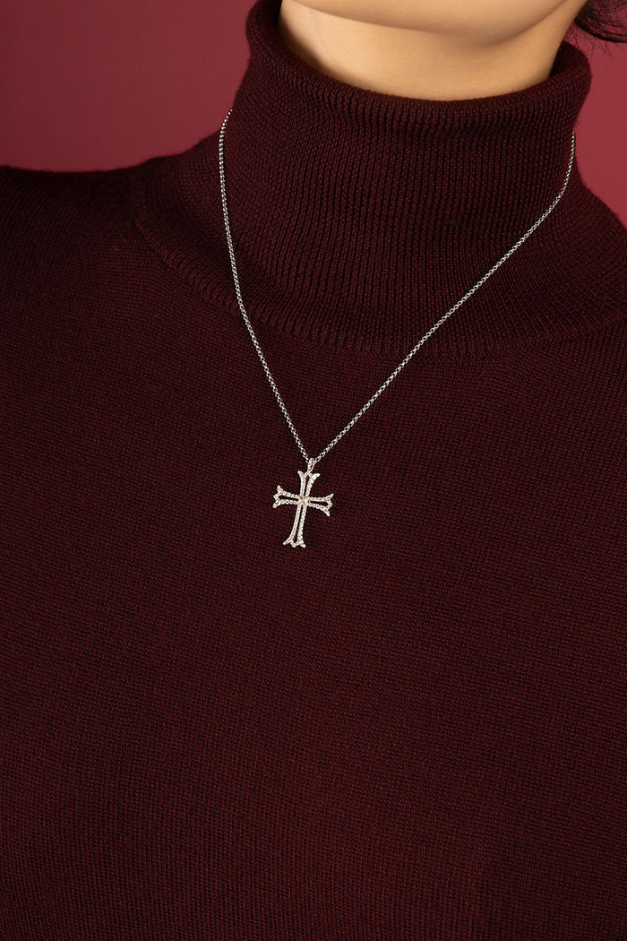 Woman wearing APM cross pendant necklace, a quiet emblem of timeless grace.