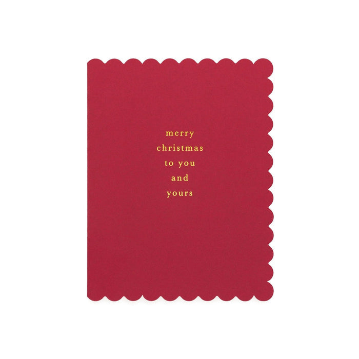Red scalloped-edge Christmas card with gold foil text reading 'merry christmas to you and yours'
