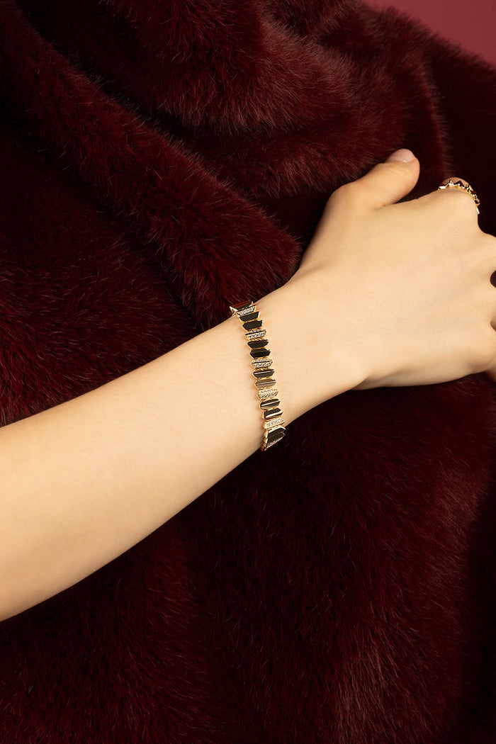 Woman wearing APM bracelet, bold geometry meets velvet allure.