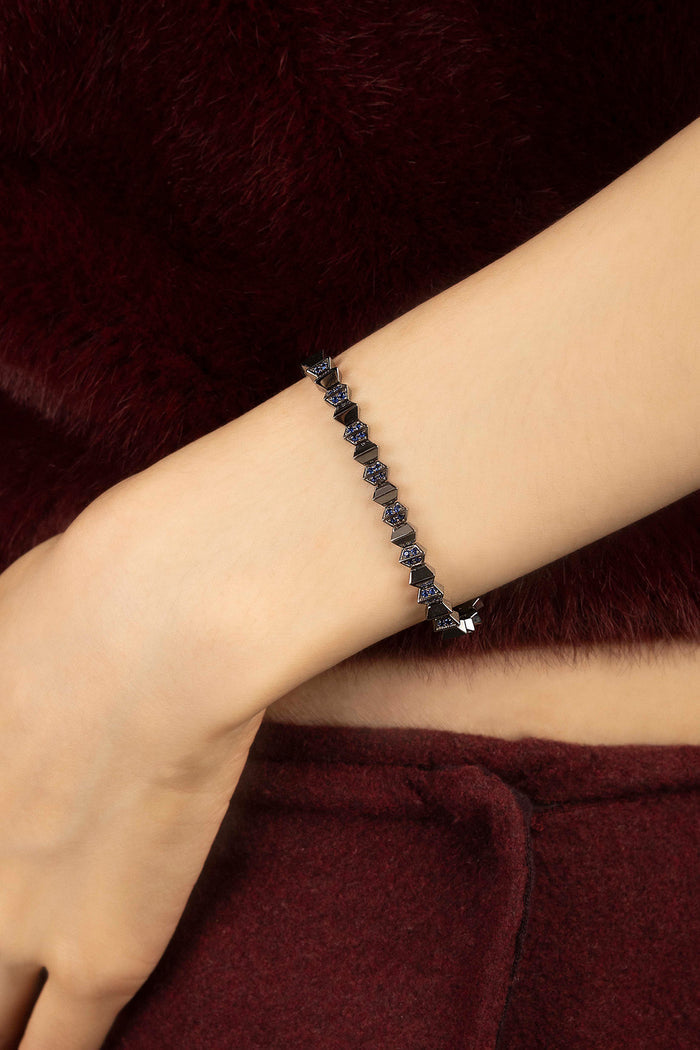 Woman wearing APM Monaco bracelet, a bold edge against soft burgundy.