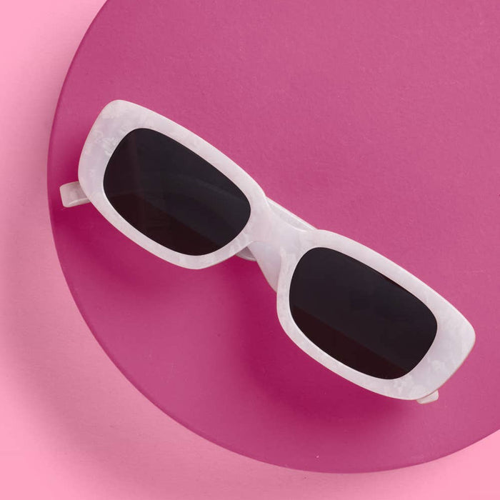 White XO FETTI Wifey sunglasses with dark lenses on pink circular background